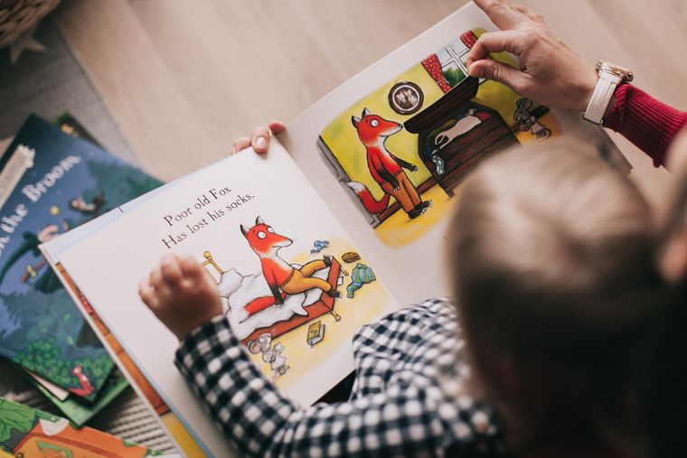 Un adulte et un enfant lisent un album ensemble